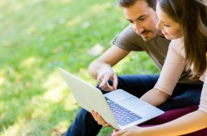 couple reviewing bank account online in park